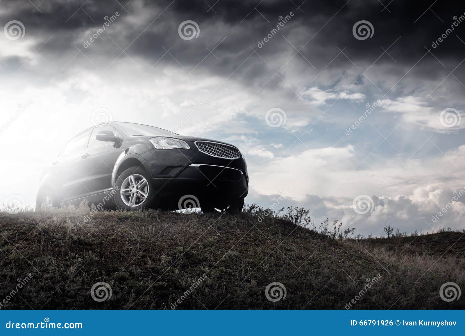 Black Car Stay on Hill in Dramatic Clouds at Daytime Stock Photo