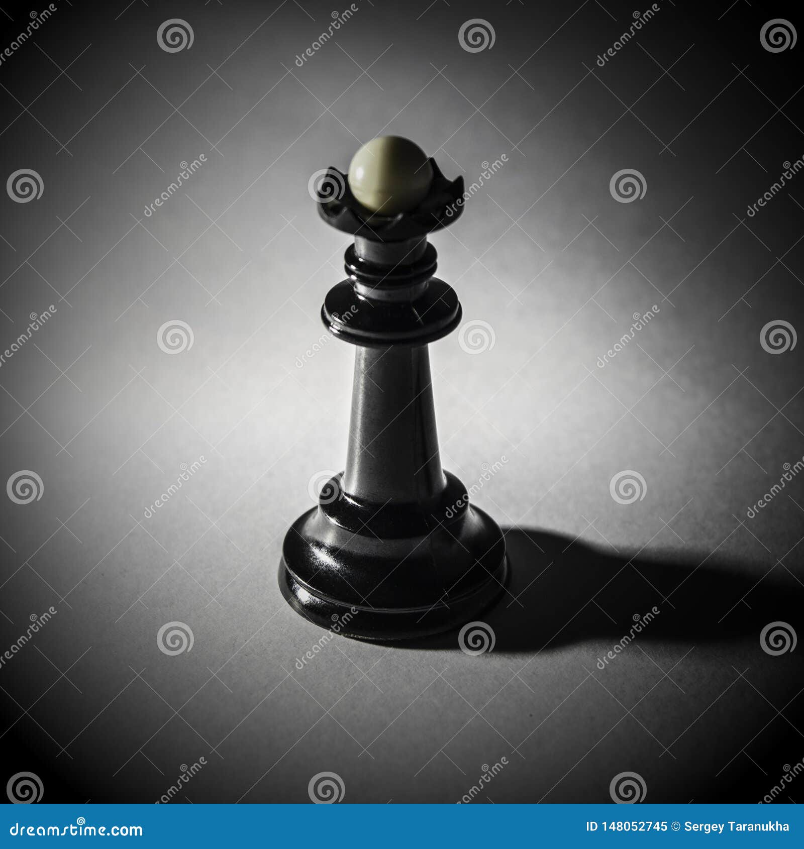 Black Chess Queen Stands on a White Background, Tight Shadow