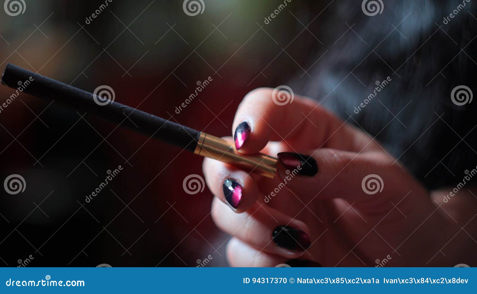Black Cigarette with Golden Filter in Woman`s Hand Stock Photo Image