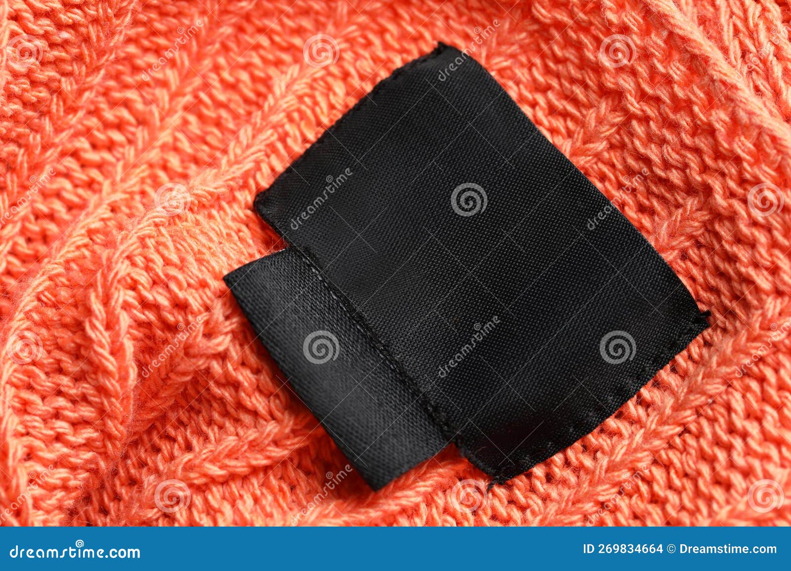 Black Clothing Labels on Orange Garment, Top View Stock Photo - Image ...