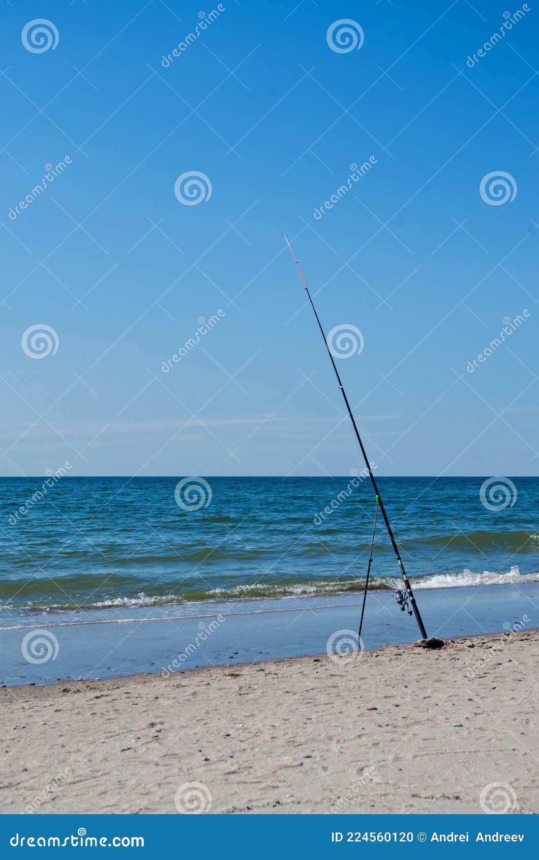 Black Composite Fishing Rod with Red Tip and Reel with Fishing Line  Attached To Handle Stuck in Sand and Leaning on Slingshot. Stock Photo -  Image of peace, leaning: 224560120