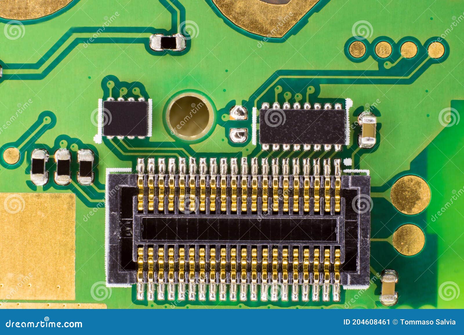 A Black Connector with Gold Contacts on a Green Circuit. Overhead Image of a Black Micro