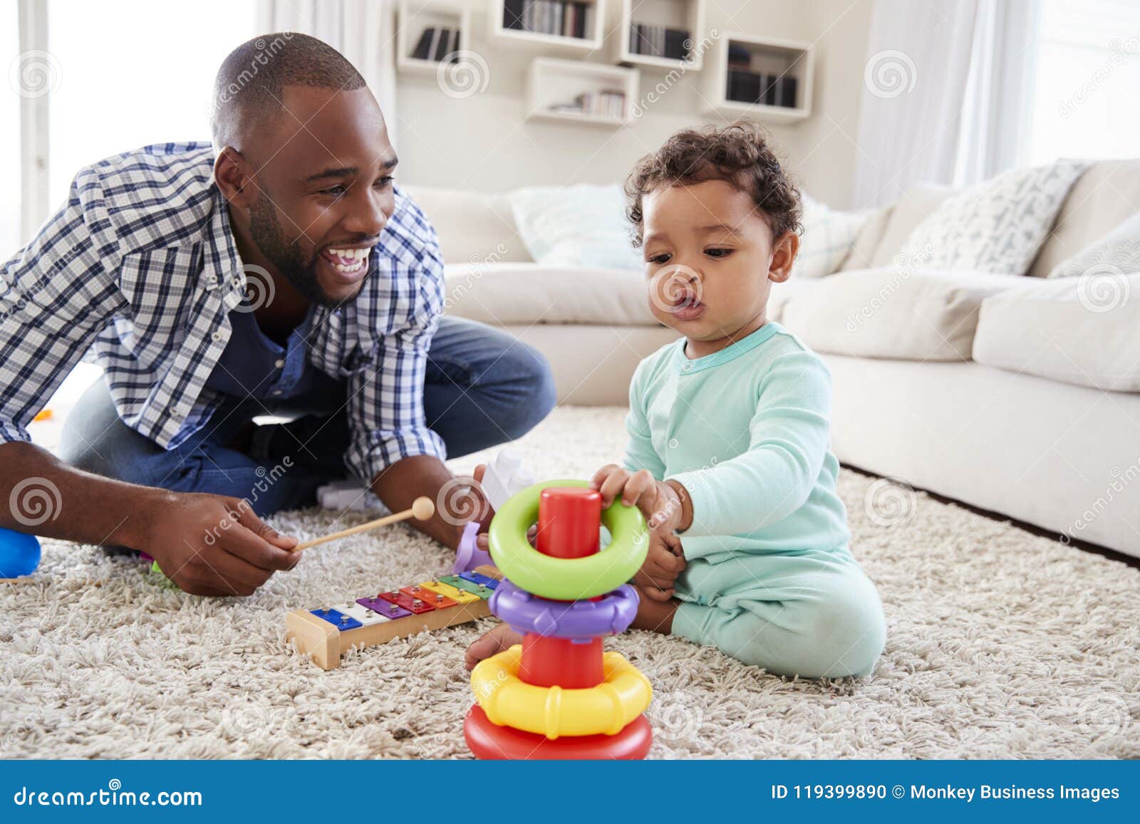black dad and toddler son playing on floor at home, close up