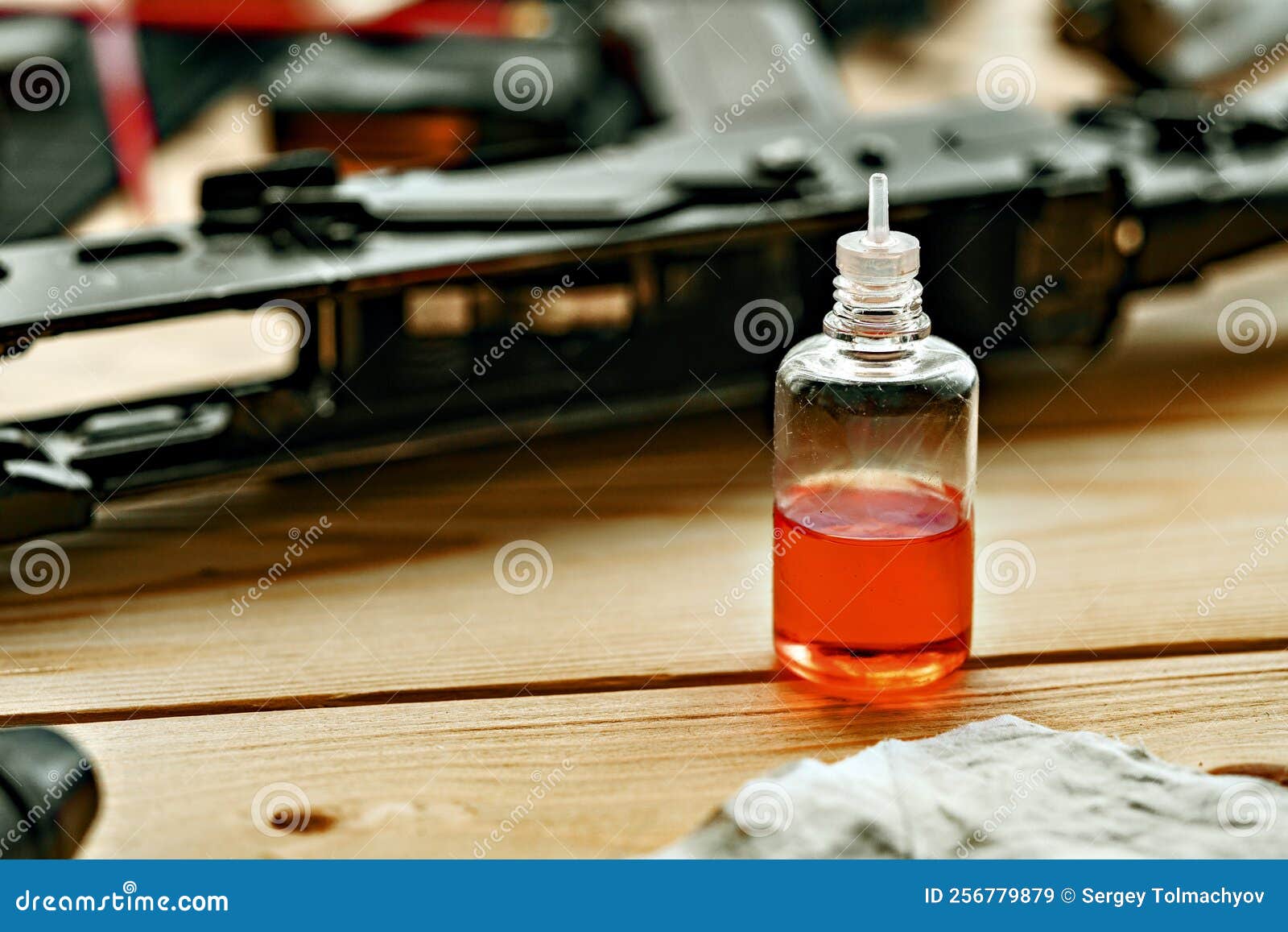 Black Disassembled Shotgun and Cleaning Tools on Wooden Table . Stock