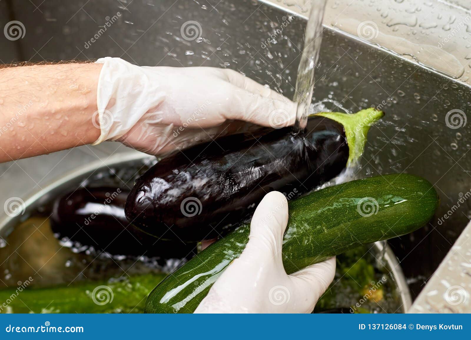 Black Eggplant Rinsing by Stream of Tap Water. Stock Photo Image of