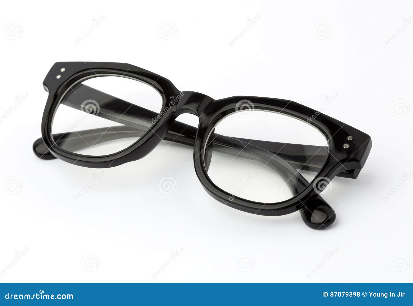 Glasses With Folded Arches Lie On A Yellow Surface. Above Lies A Lens