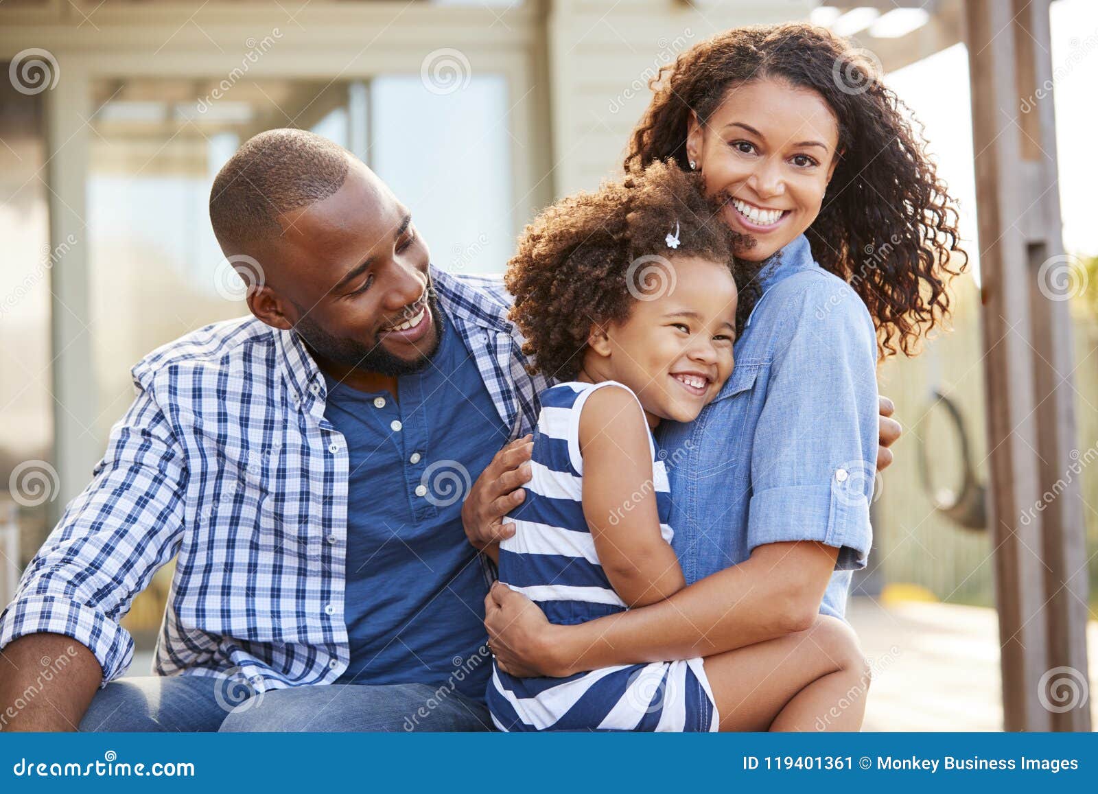 black family embracing outdoors smiling to camera outside