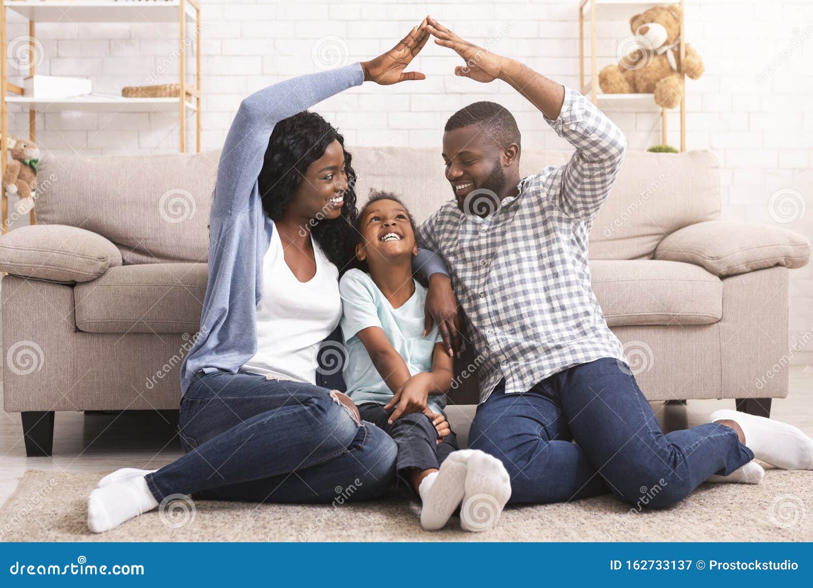 black family making ic roof of hands above little girl