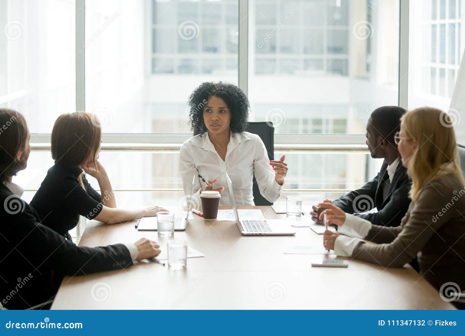 black female boss leading corporate meeting talking to diverse b