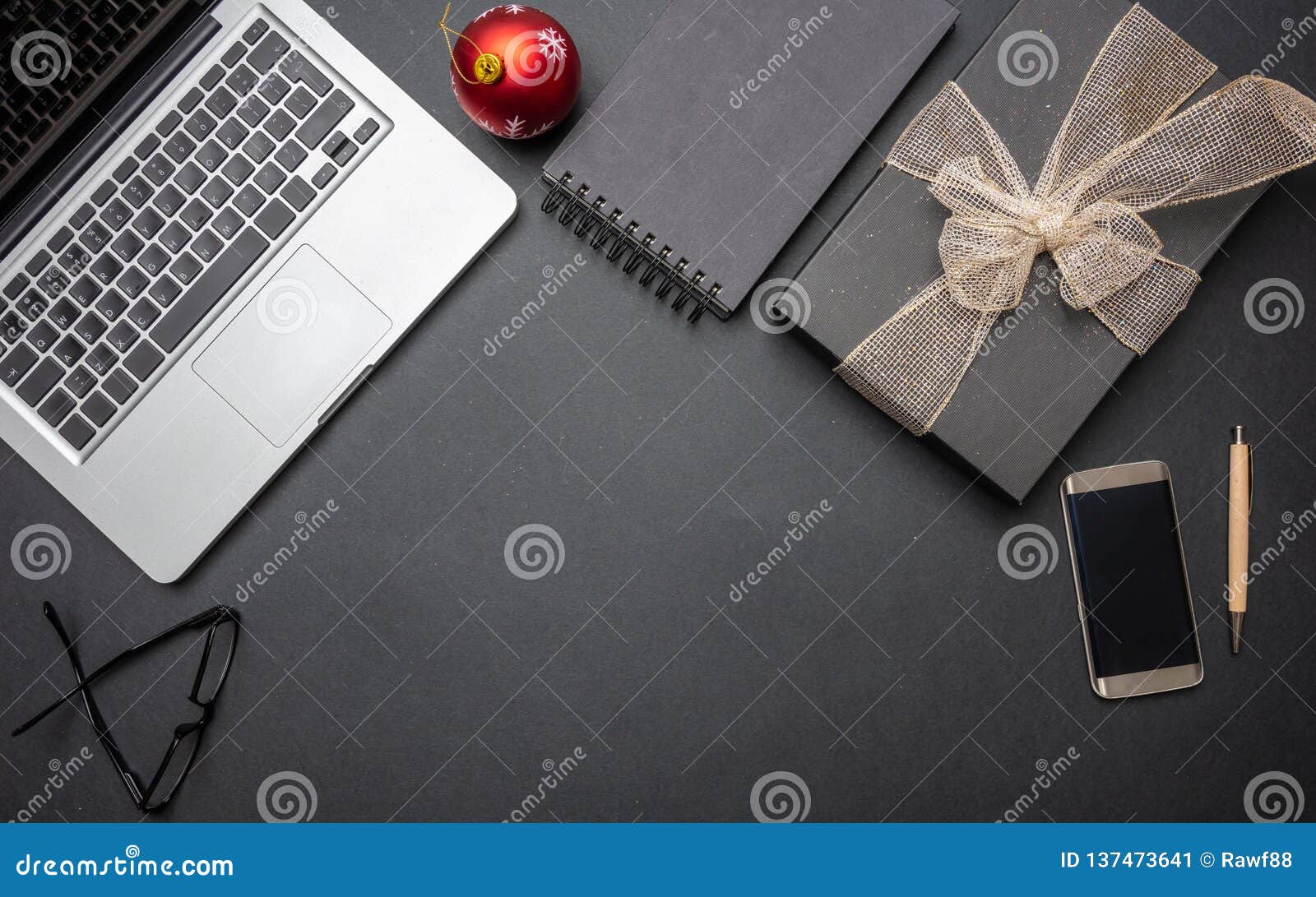 Black Gift Box With Shiny Ribbon On Black Office Desk Top View