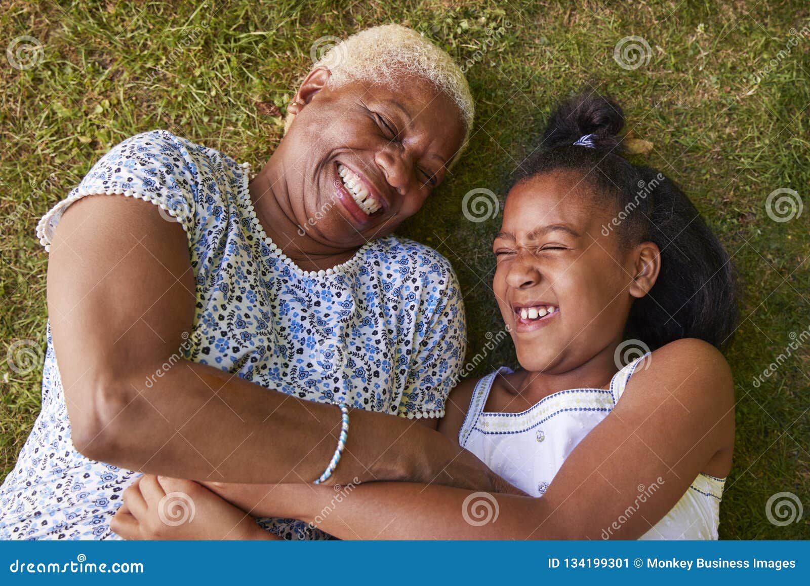 black girl and grandmother lying on grass, overhead close up