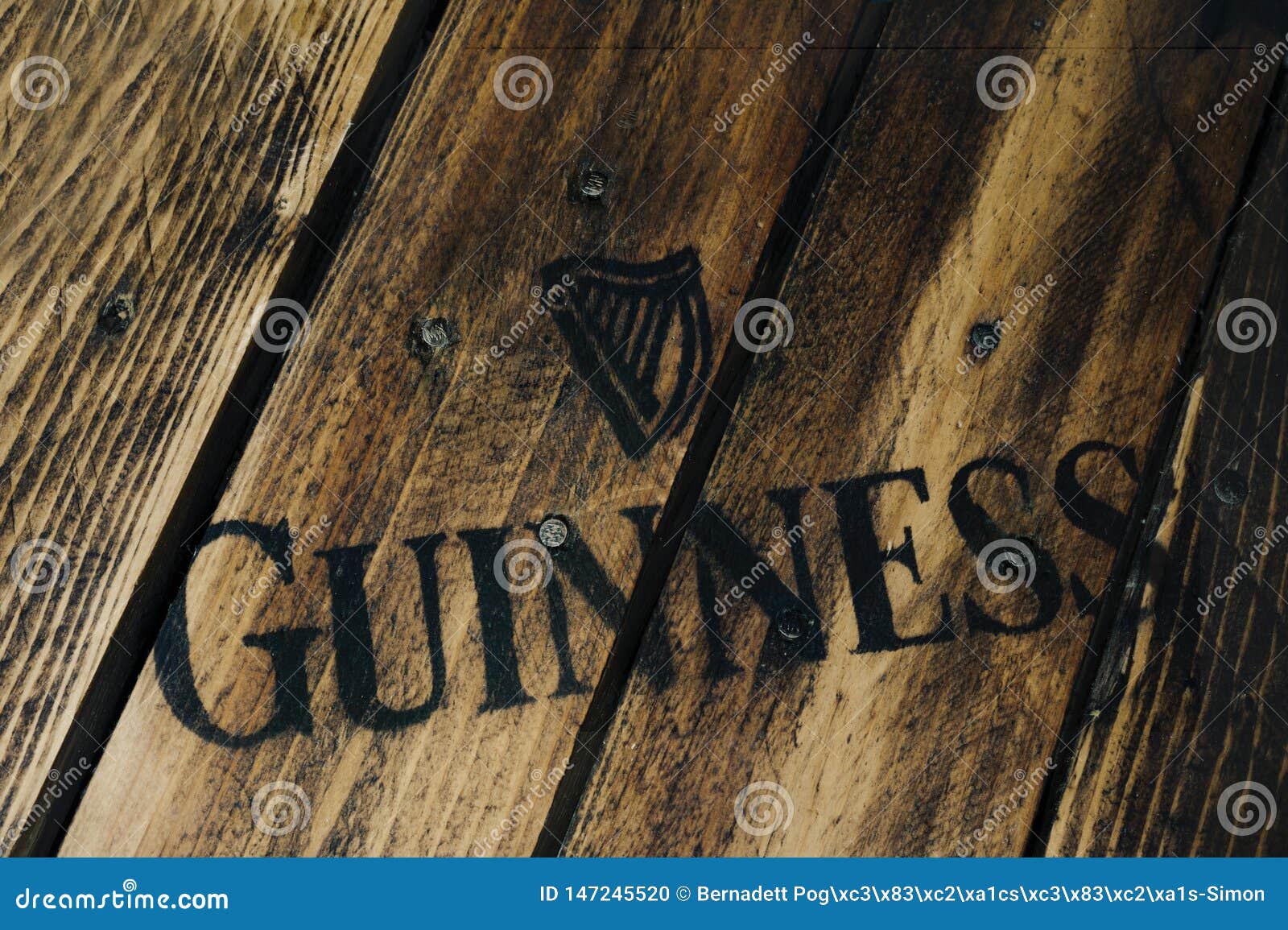 Black Guinness Beer Logo on Rustic Weathered Wood Editorial Image