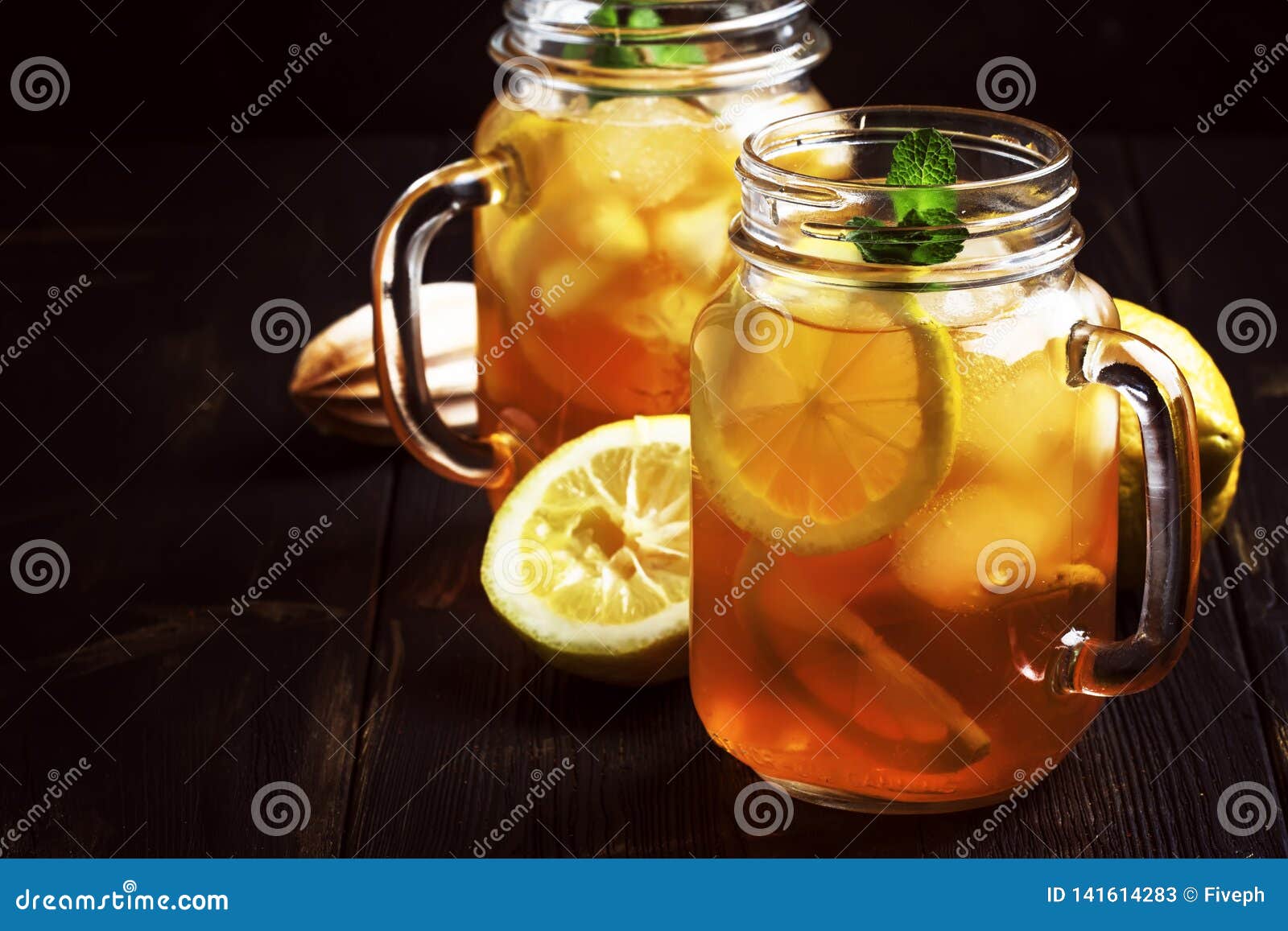 Black Ice Tea with Lemon Slice in Glass Jar on Dark Kitchen Table