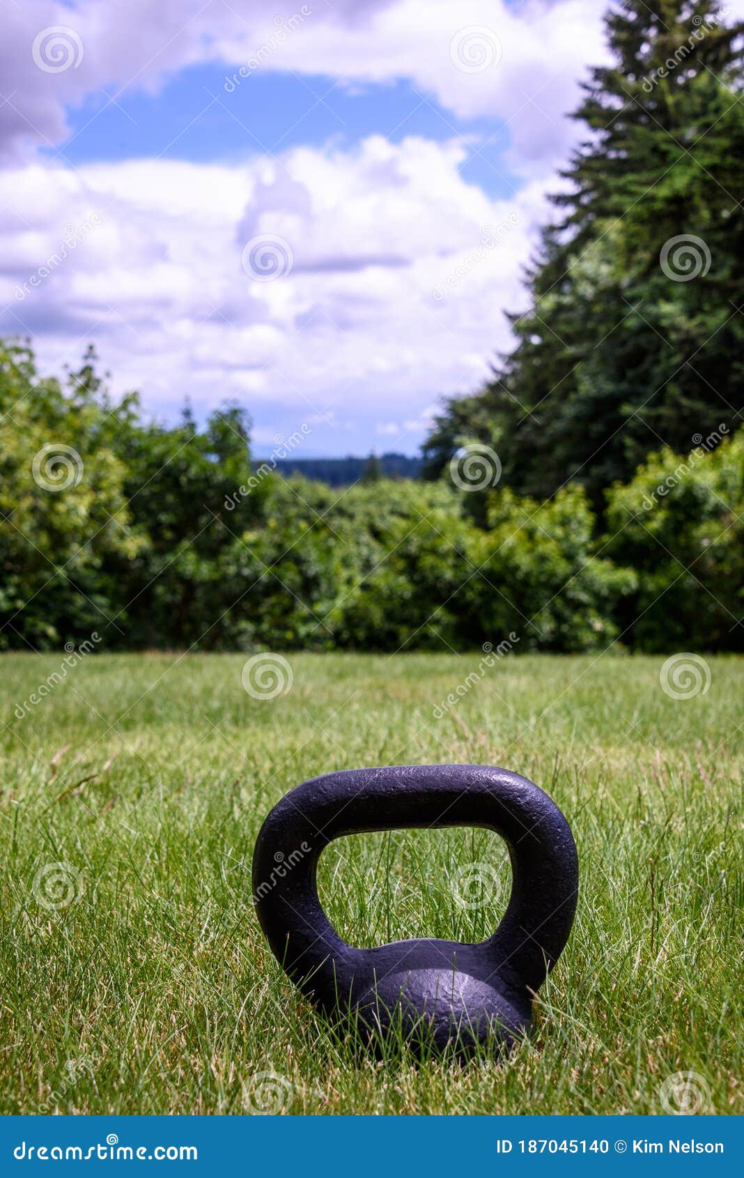 Black Kettle Bell on a Green Lawn, Ready for an Outdoor Workout Stock