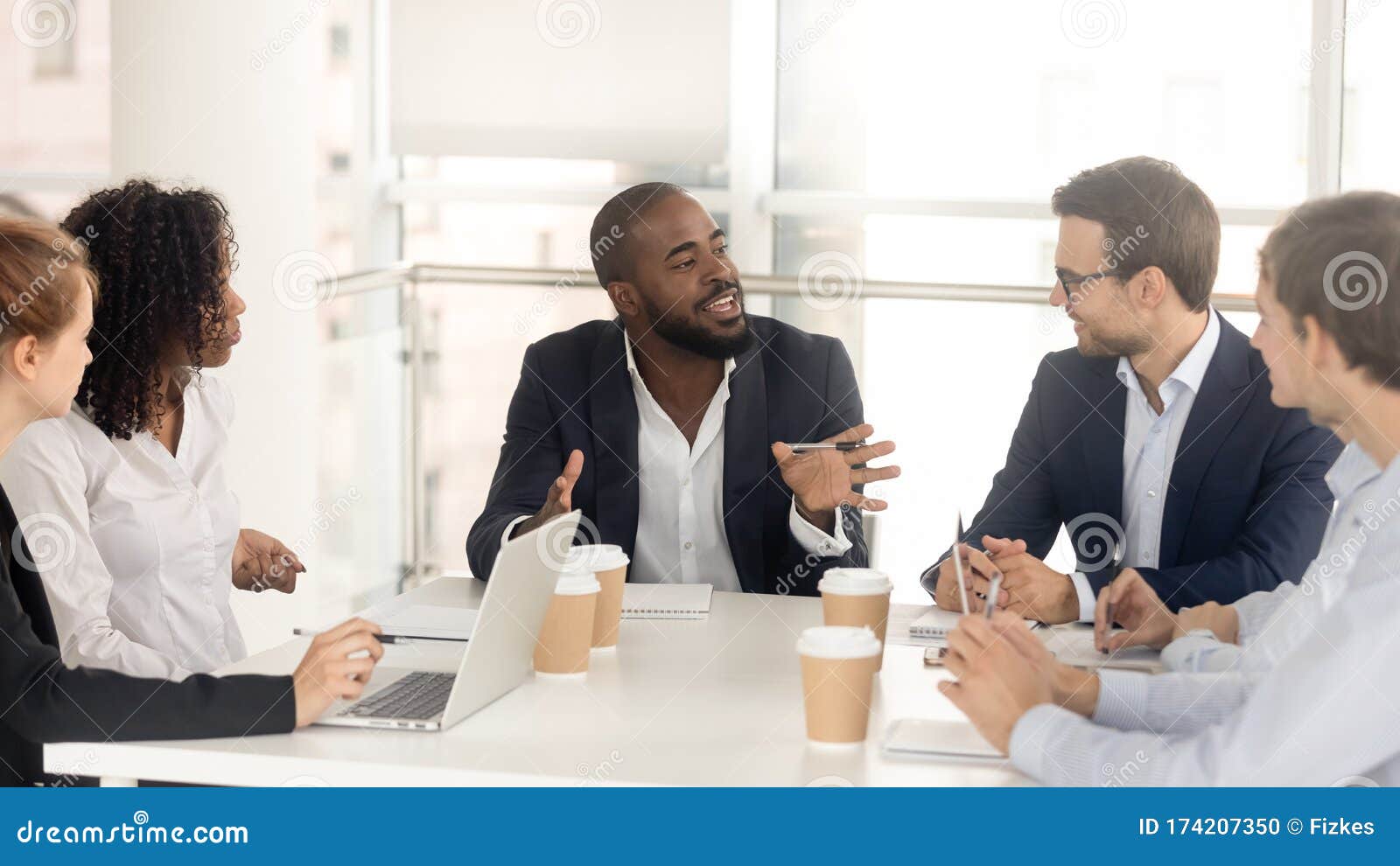 black male boss leading corporate in team meeting