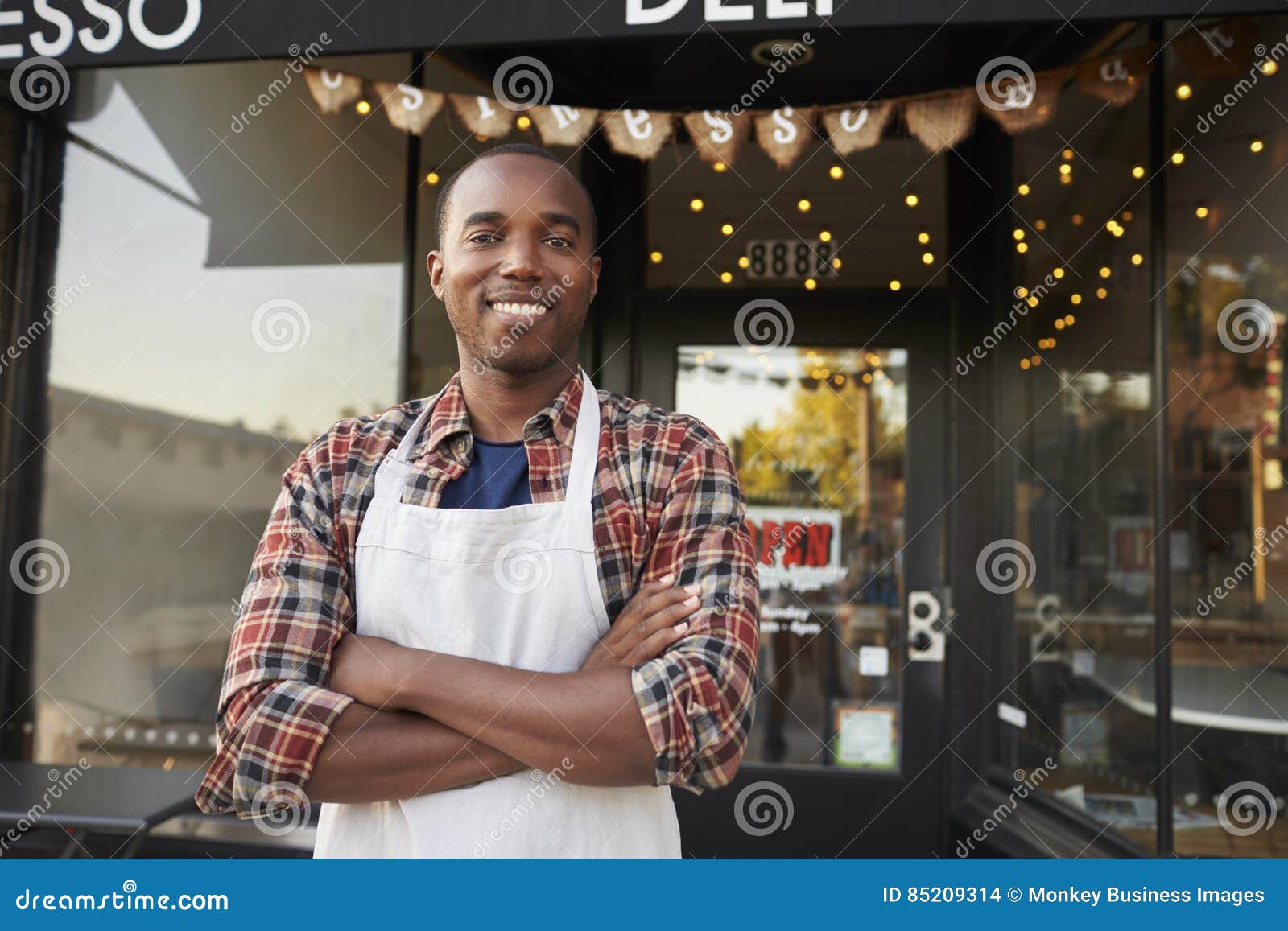 black male business owner standing outside coffee shop