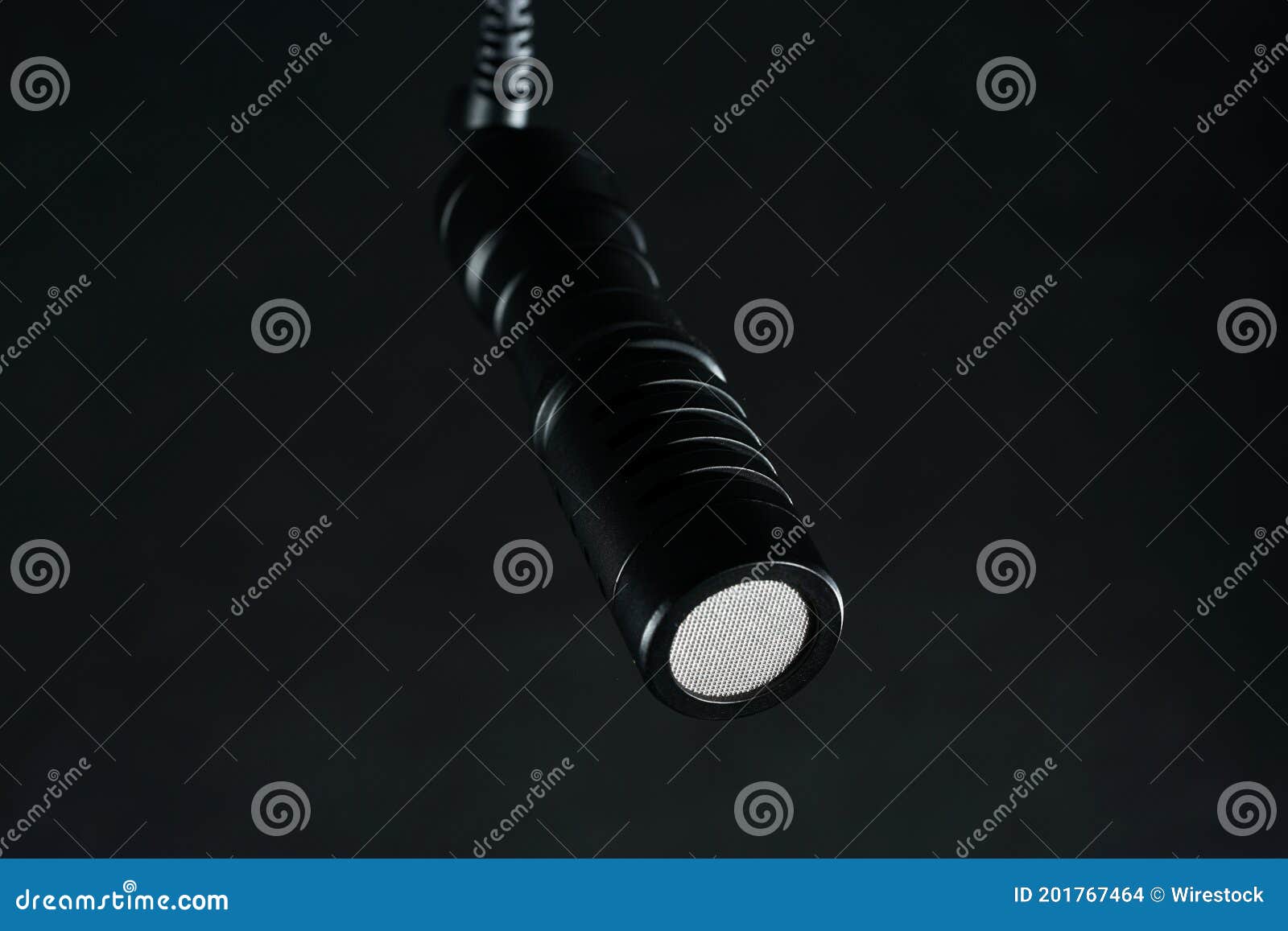 Black Microphone Hanging from the Ceiling Isolated on a Black