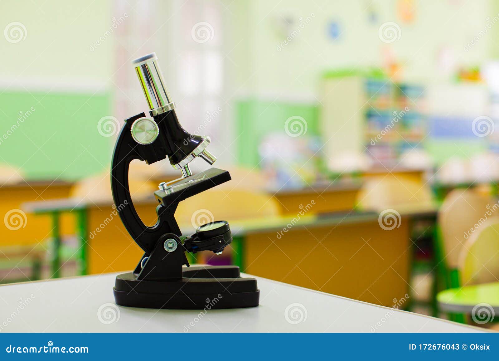 Black Microscope On Teachers Table In Empty Classroom Stock Image