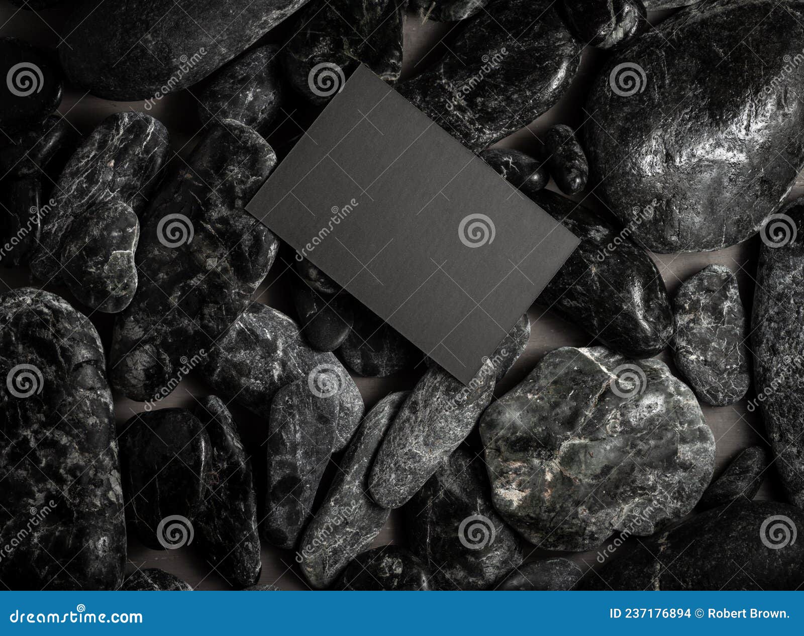 black mock up business card on black stones or galet ,concept of zen spa or sauna branding