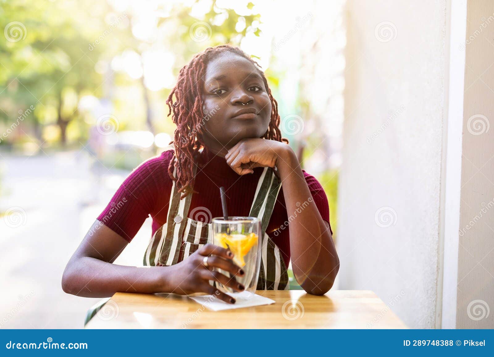 Black Nonbinary Person Sitting in an Outdoor Cafe Stock Photo Image