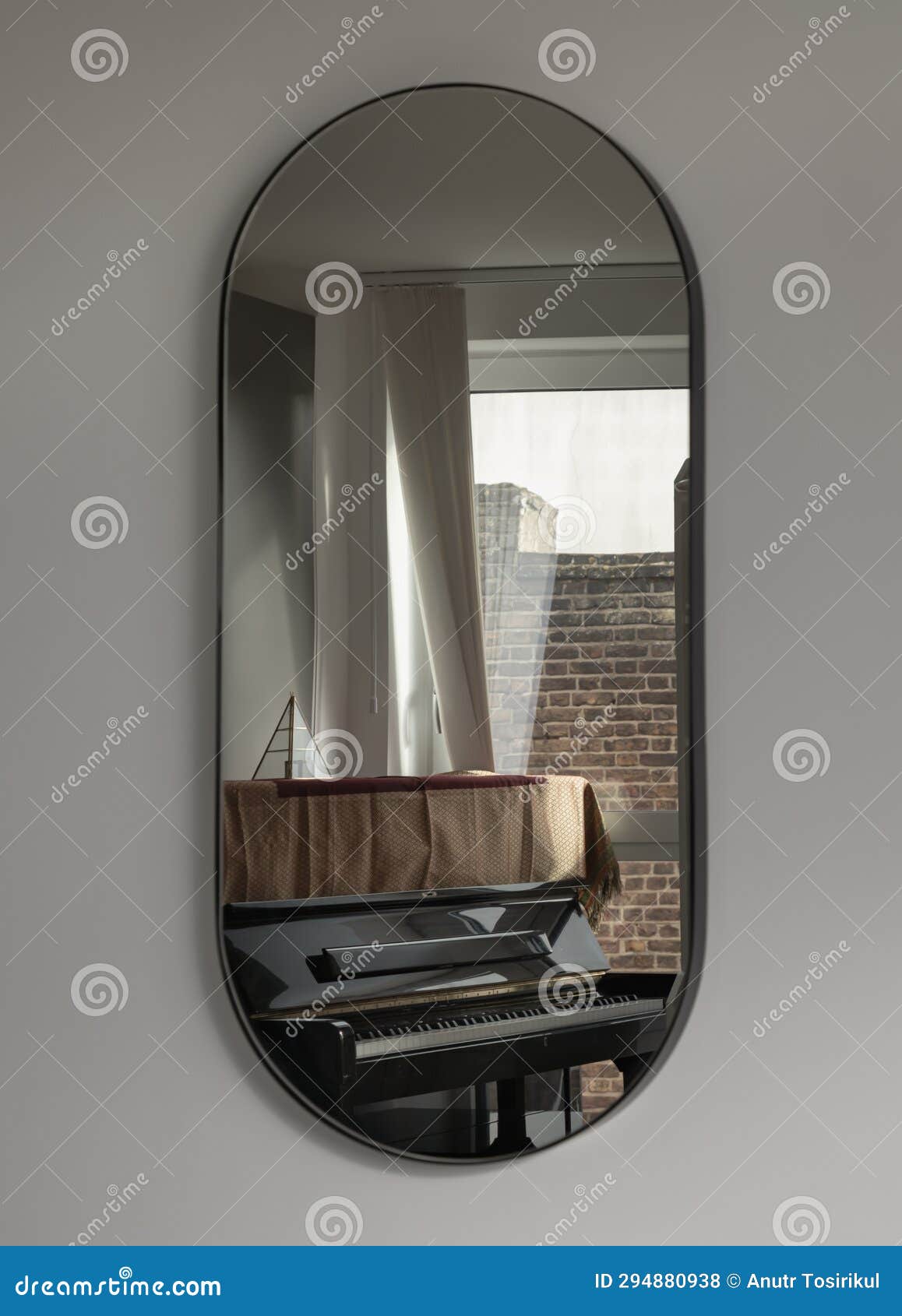a black piano by the window reflecting in the capsula pill d mirror on white wall