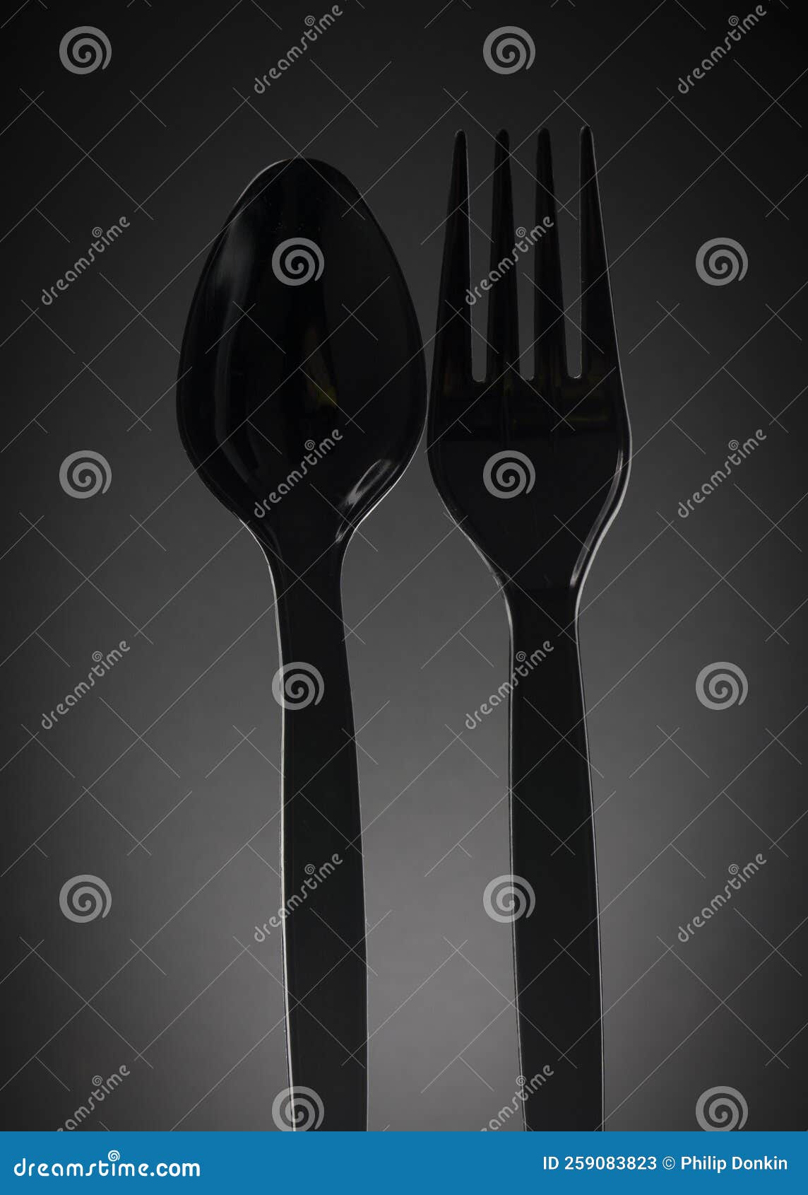 Black Plastic Fork and Spoon with Water Drops Showing Reflections and