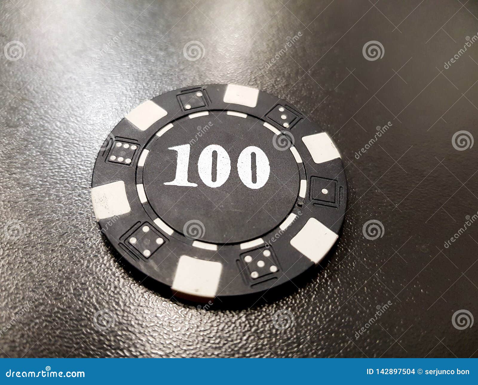 A Black Poker Chip of 100 on a Black Table Stock Photo Image of