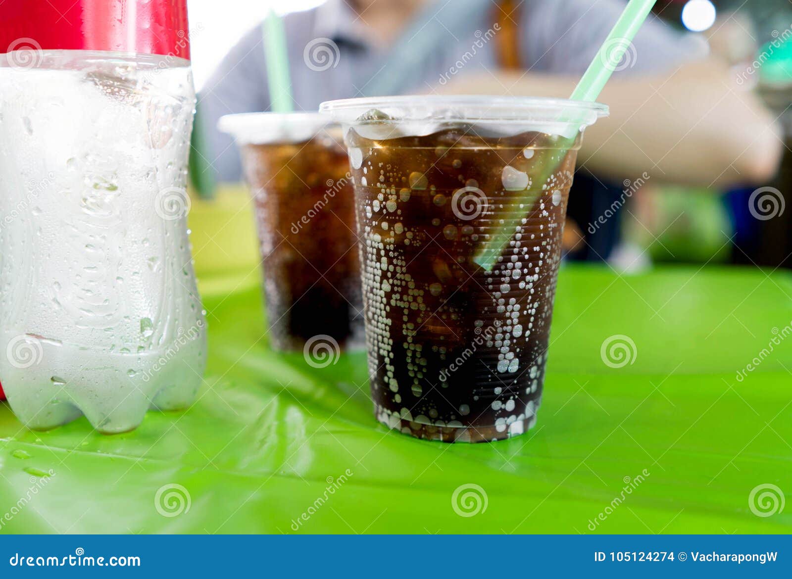Black Sparkling Cola Water with Bubbles in Plastic Cup with Stroll on