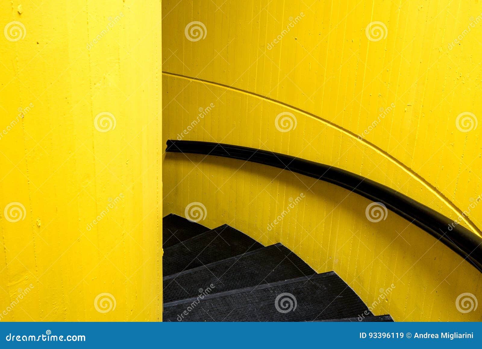 black staircase with yellw wall background and black bannister