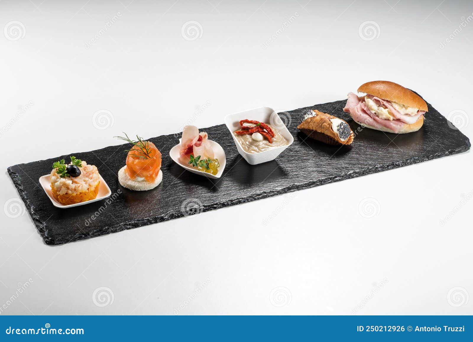 black stone rectangular tray with shrimp tartare snack cannoli swordfish ravioli with robbiola tartina nordica mousse aubergine