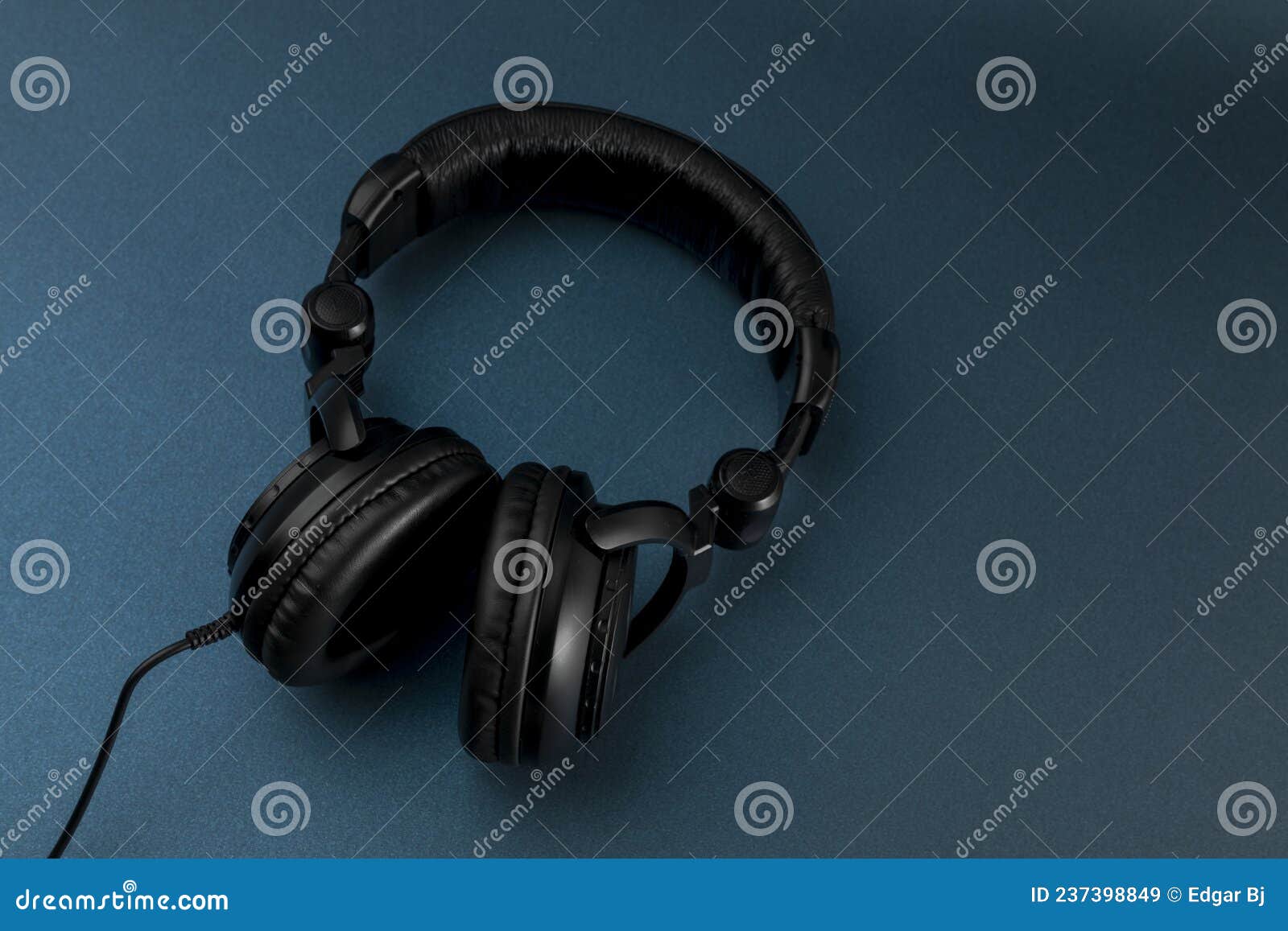 black studio headphones with blue background and space for text