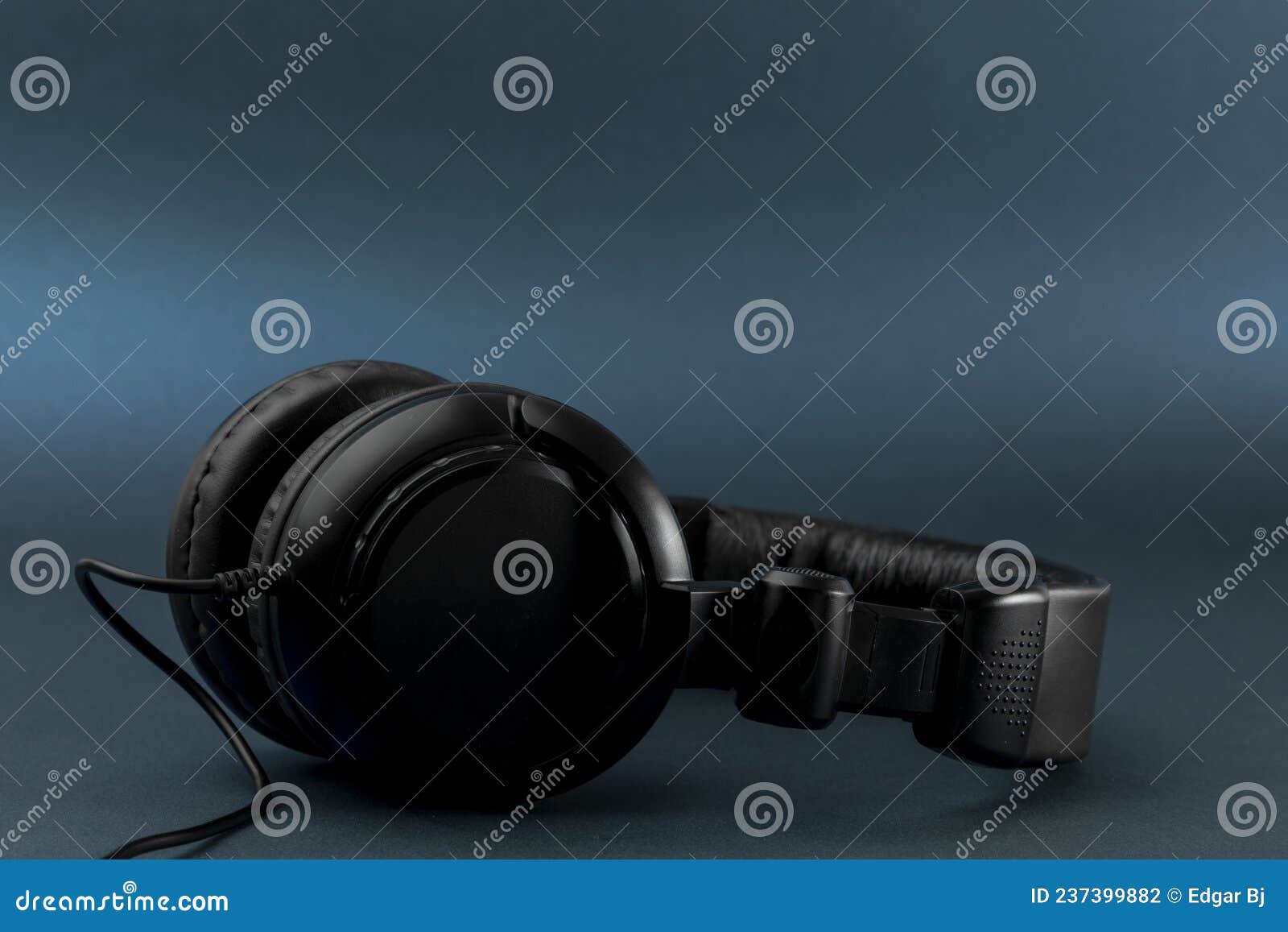 black studio headphones with blue background and space for text