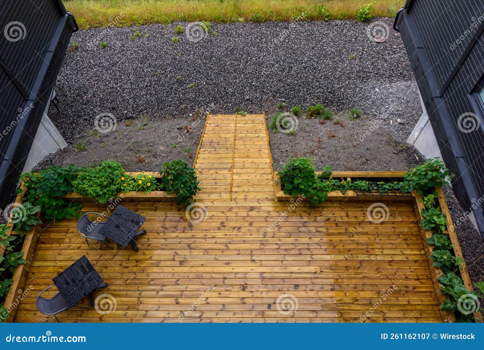 black tables and chairs on a wooden floor of an entrance surrounded by greens