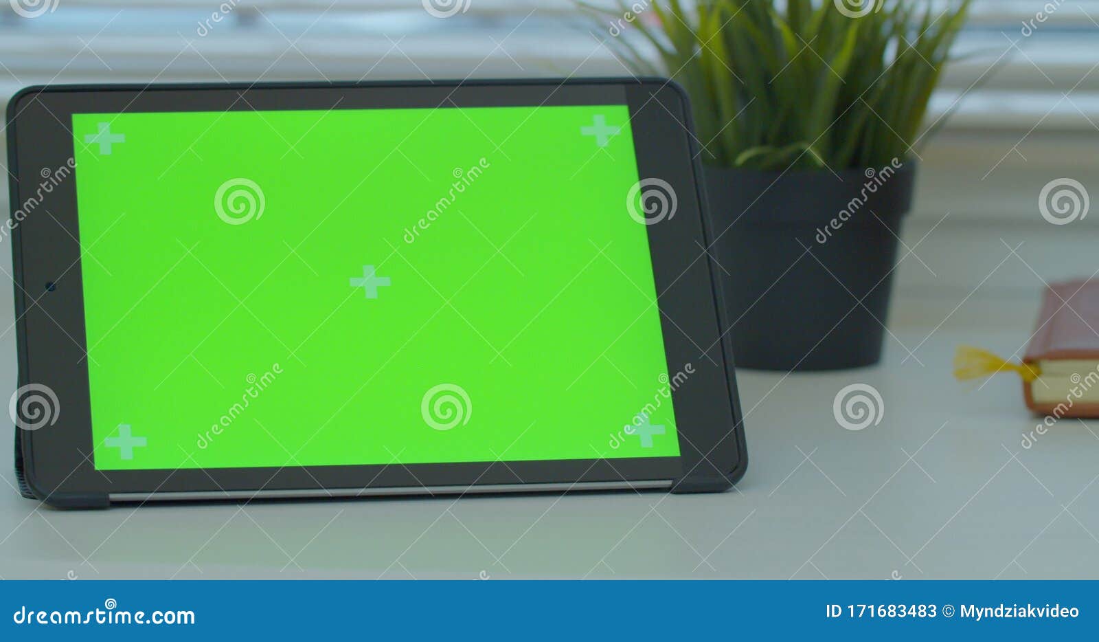 black tabletpc on a desk with green screen and book. close up 4k footage.