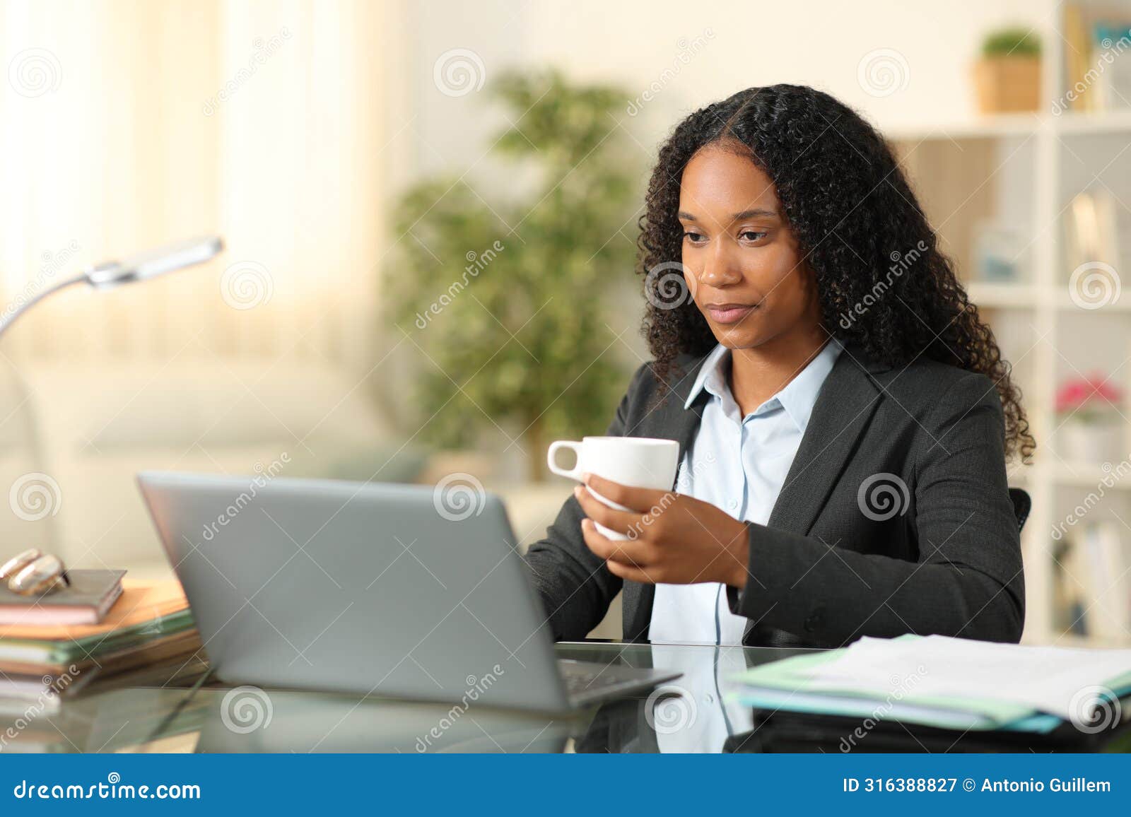 black tele worker drinking and working at home