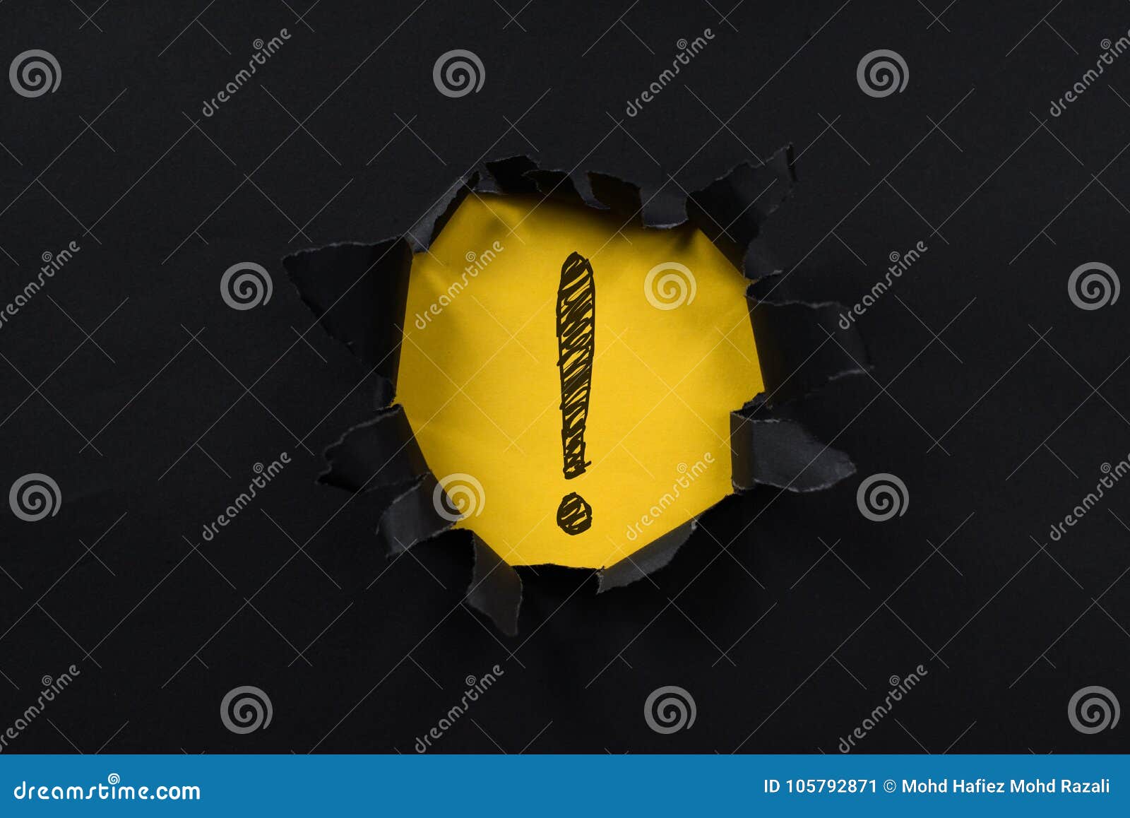 black torn paper revealing exclamation mark on yellow paper