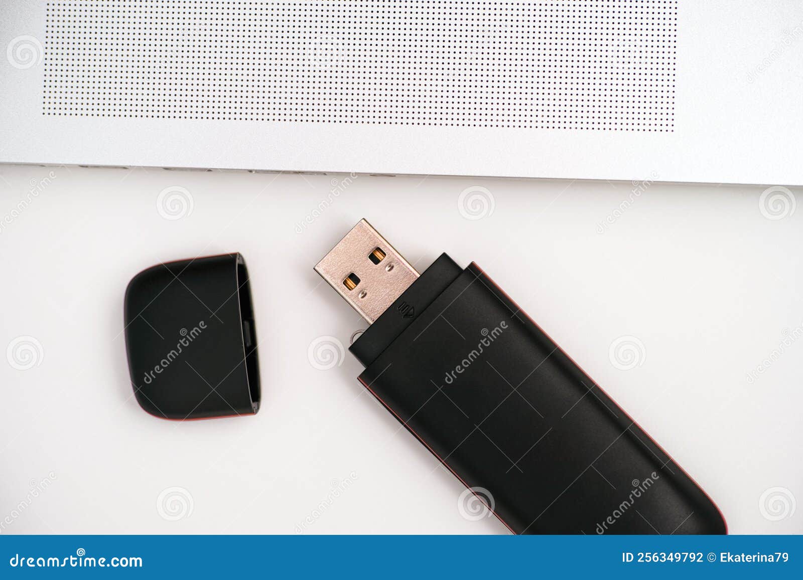 A Black USB Flash Drive with it Cap Lying Near a Laptop on the Table