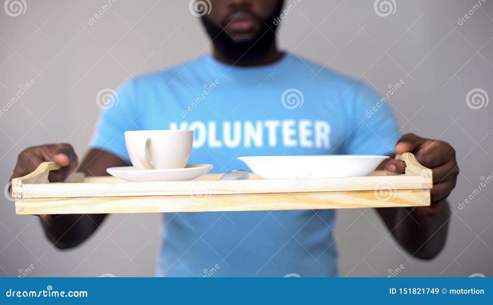 black volunteer holding serving tray, helping patients in rehabilitation center