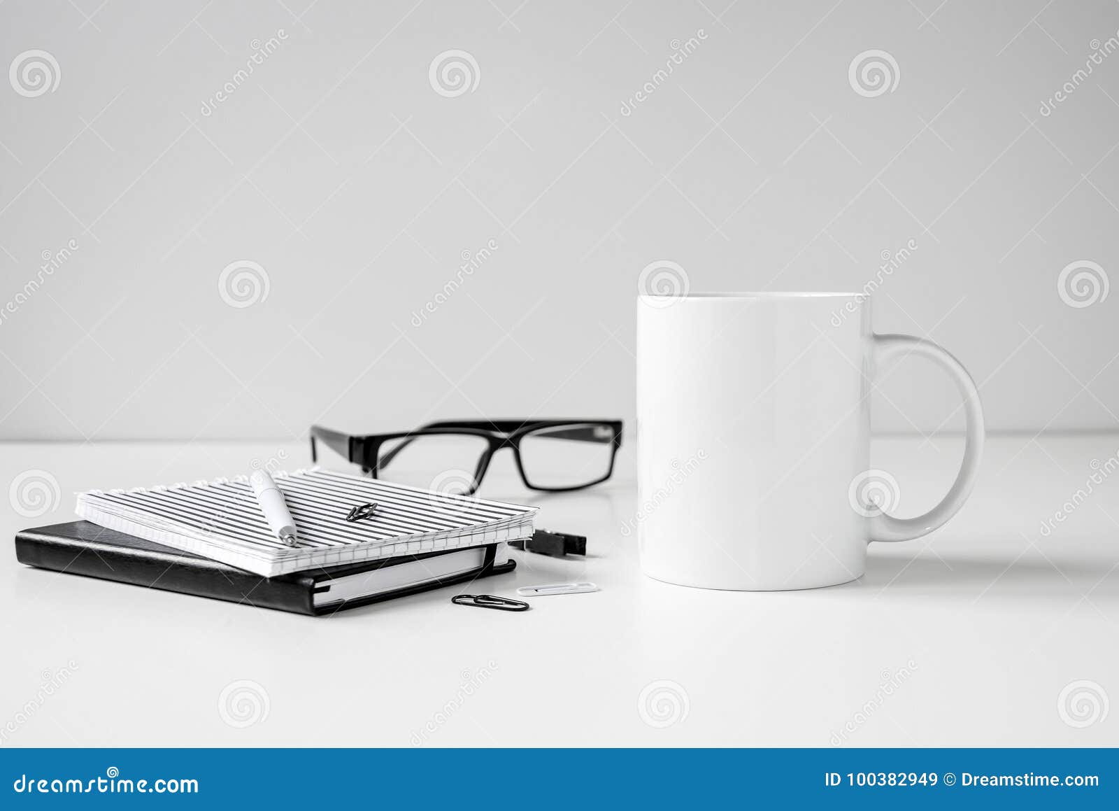black and white coffee mug mock up with notebooks, pen and eyeglasses