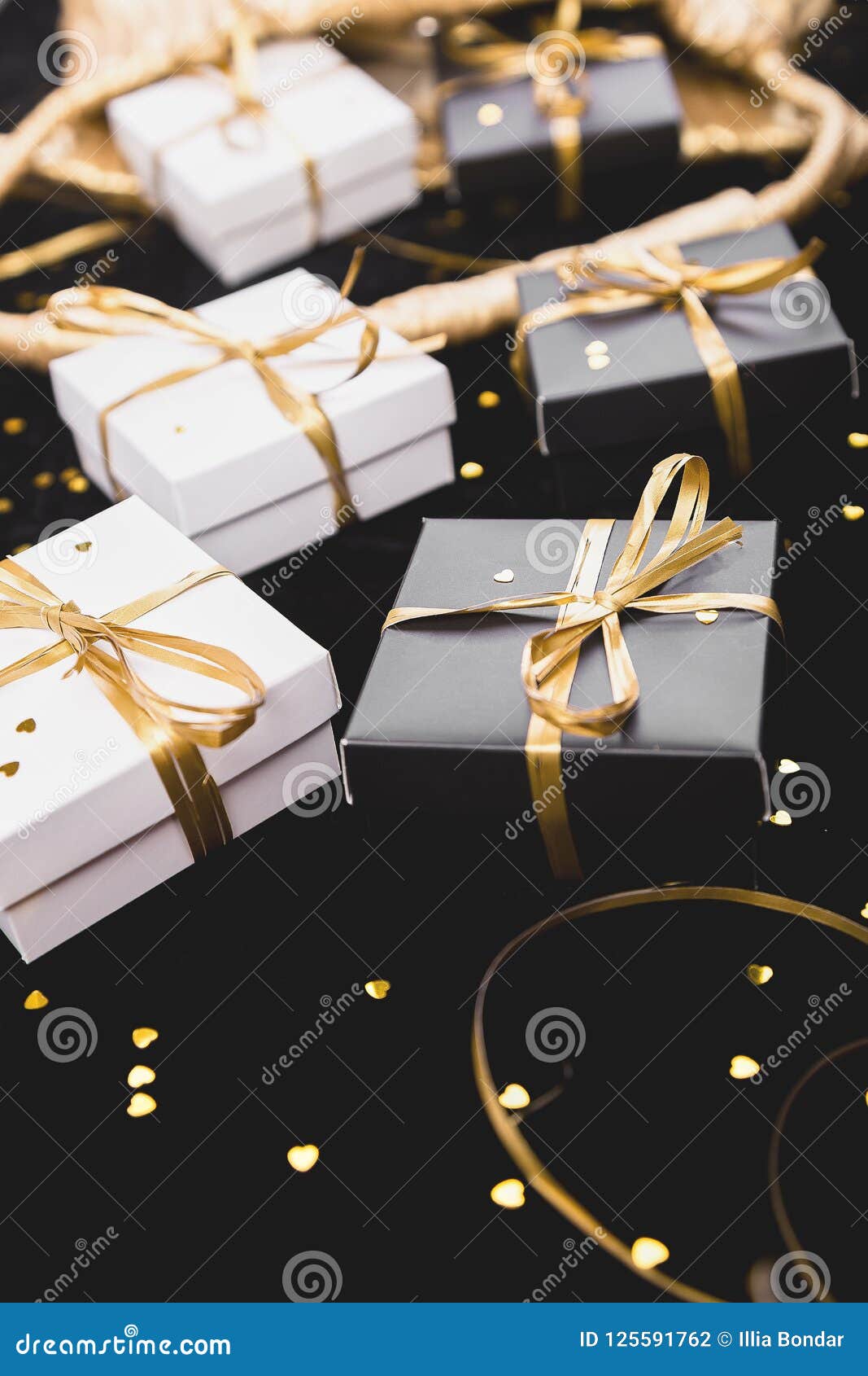 Black And White Gift Boxes With Gold Ribbon On Shine Background. Stock