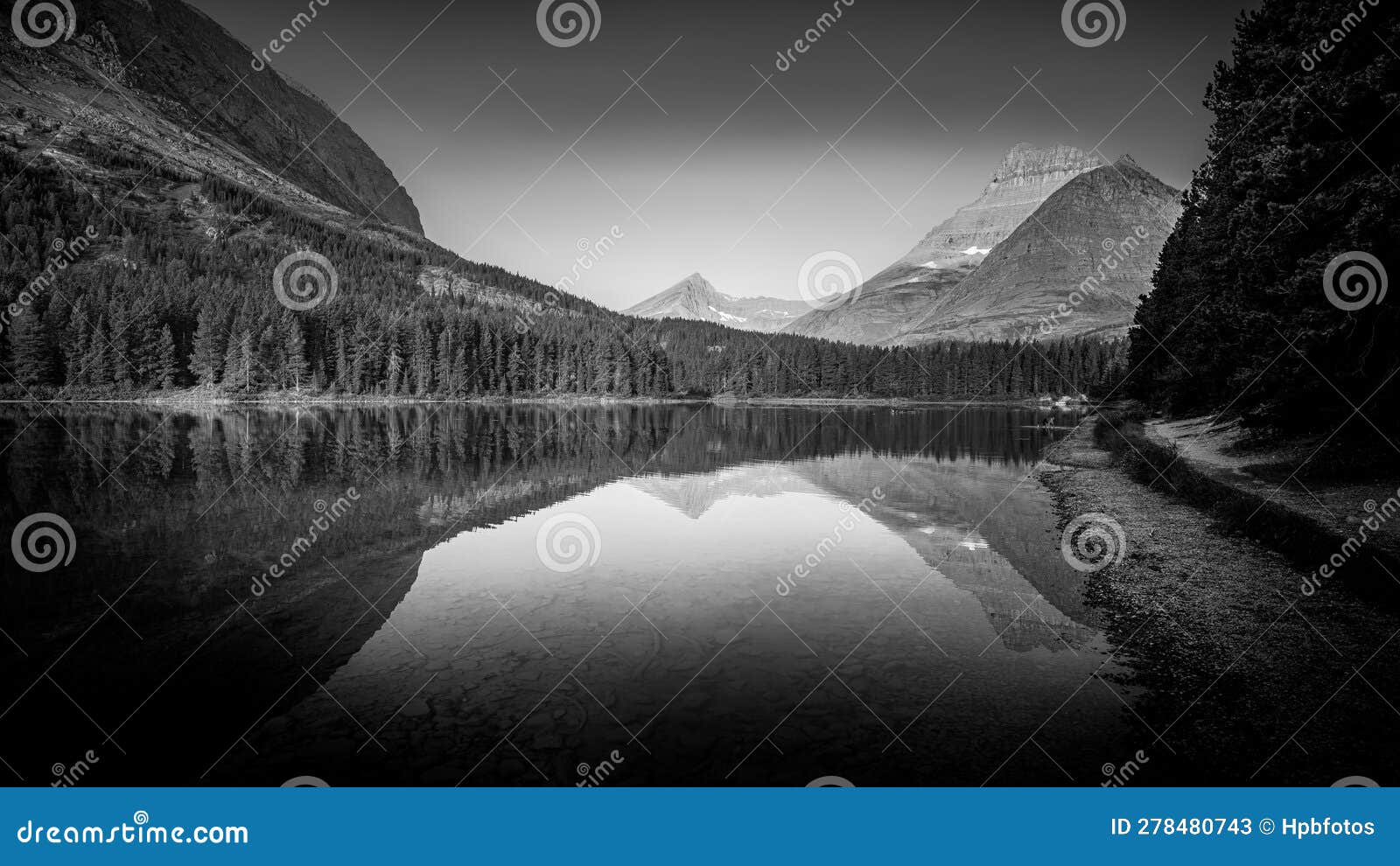 black and white landscape photo of mt. wilbur reflection in fishercap lake at sunrise in glacier national park