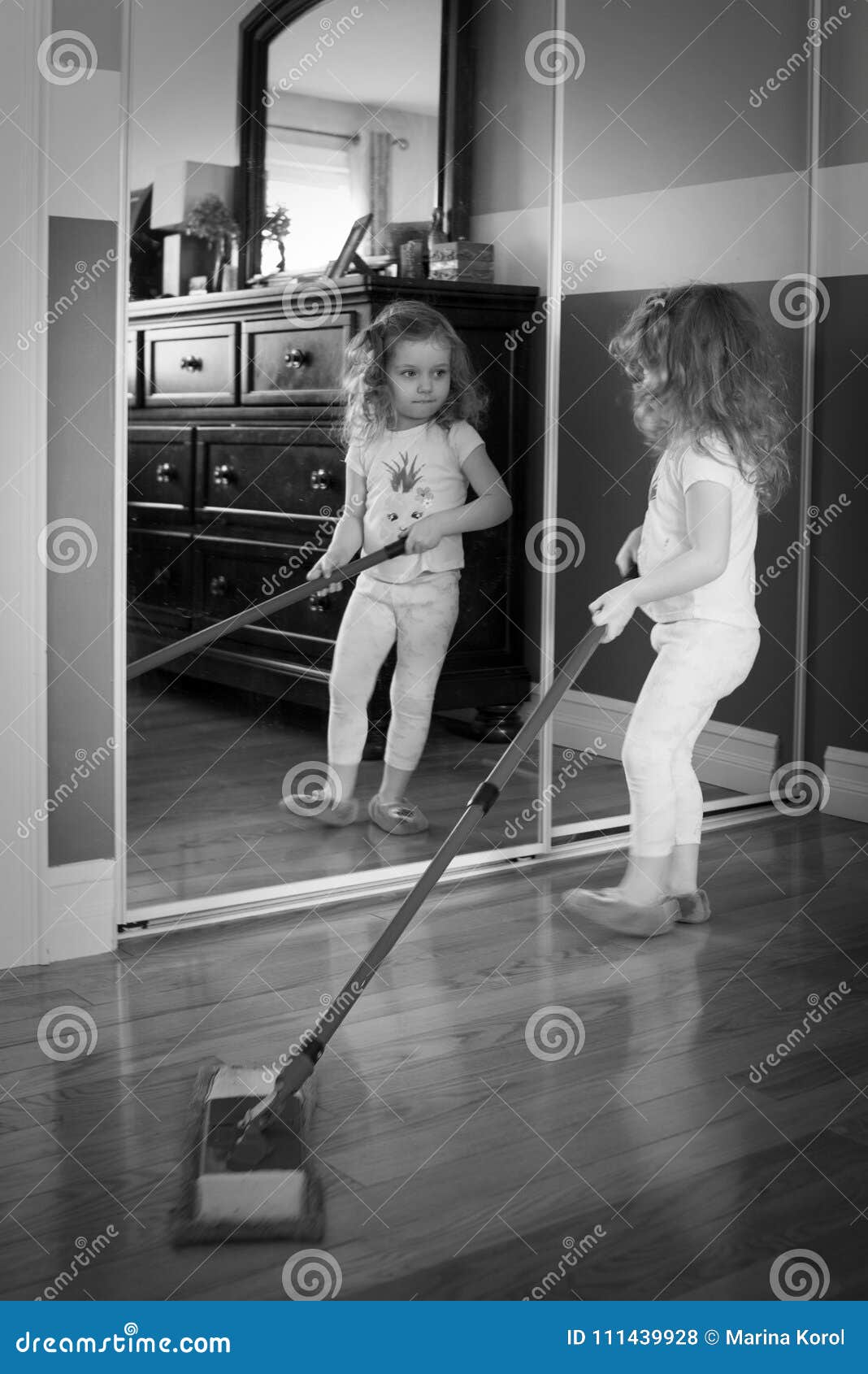 black and white photo of little white girl girl is helping help cleaning house
