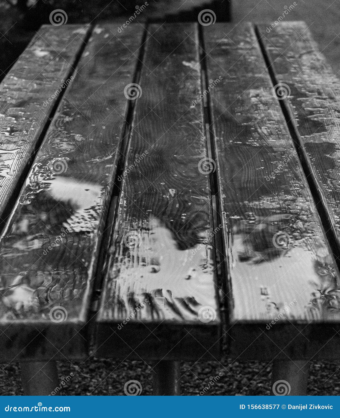 black and white photo of wet wooden table