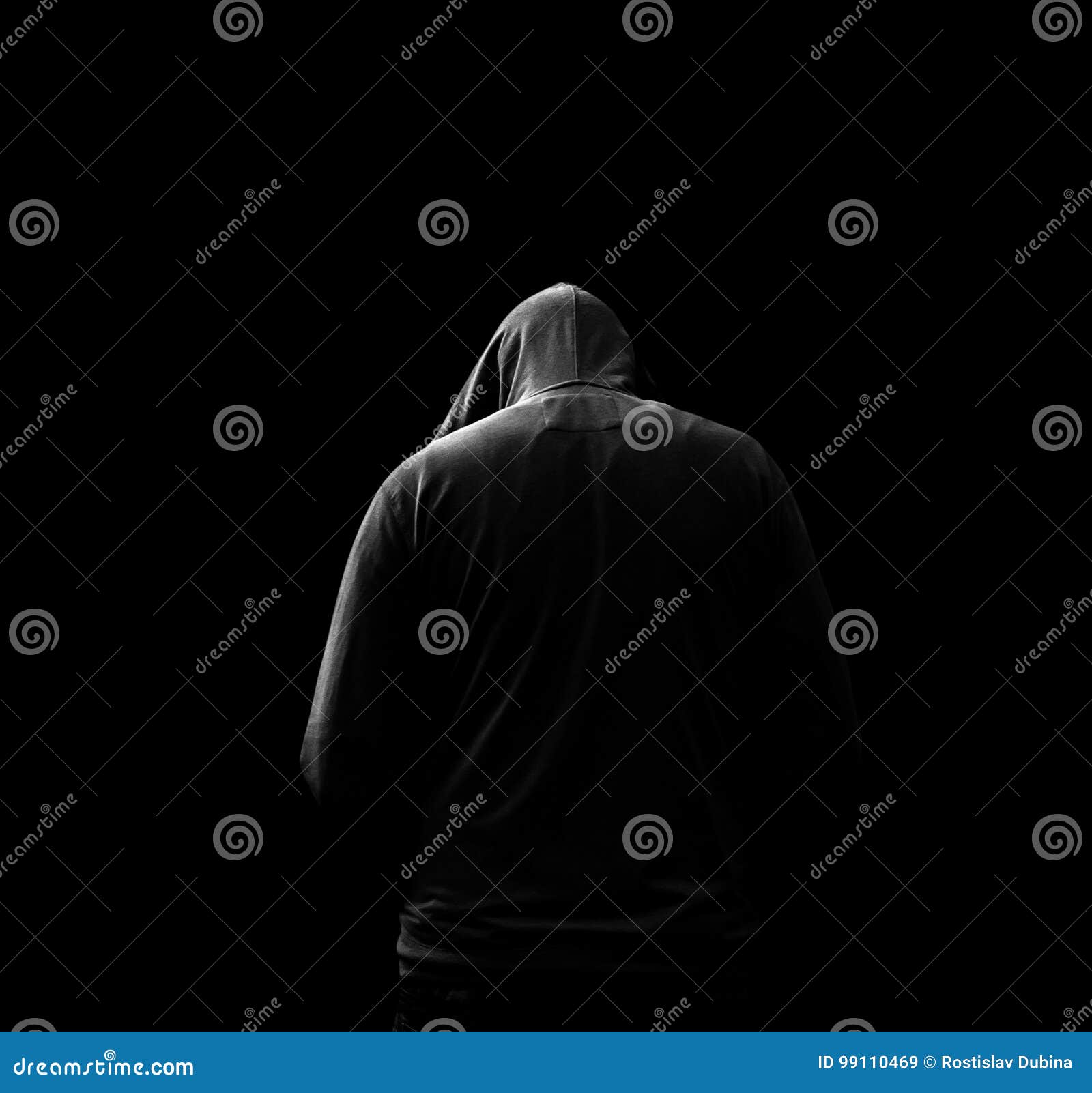 black and white silhouette of a hooded man, who turned away,  on black background.