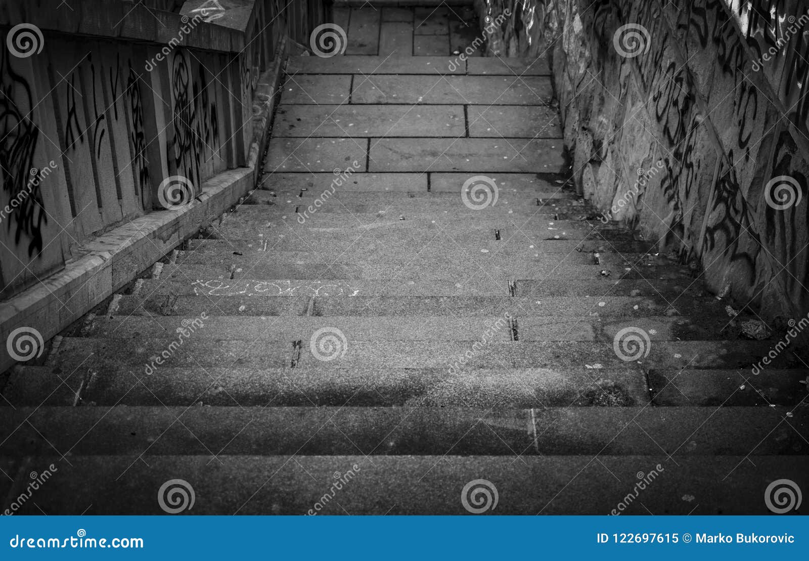 black and white stairs going down with a lot grafiti