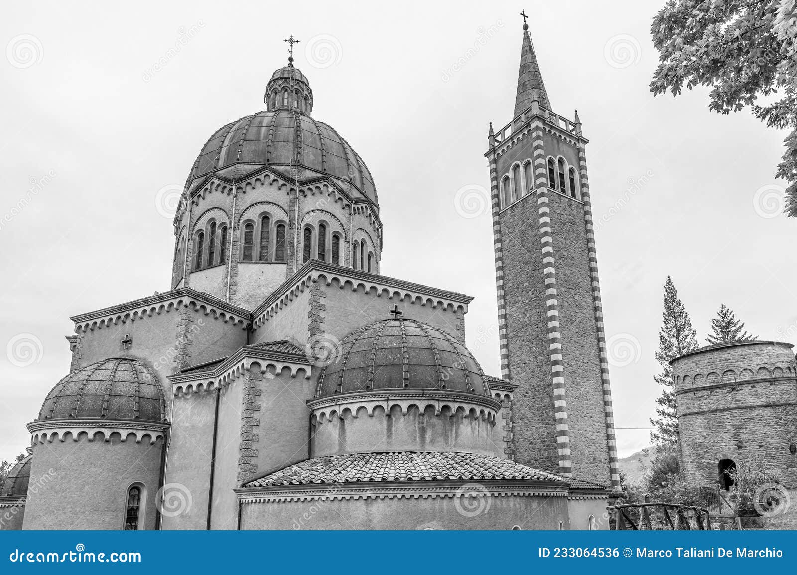 black and white view of parish church of san mamante and delubro, lizzano in belvedere, italy, under a dramatic sky