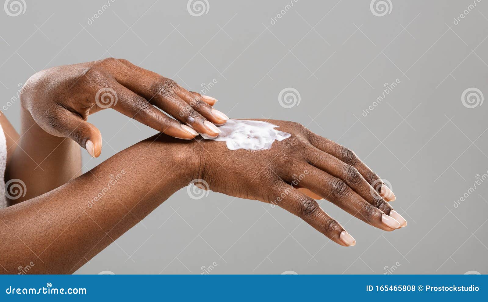black woman applying body lotion to her hands