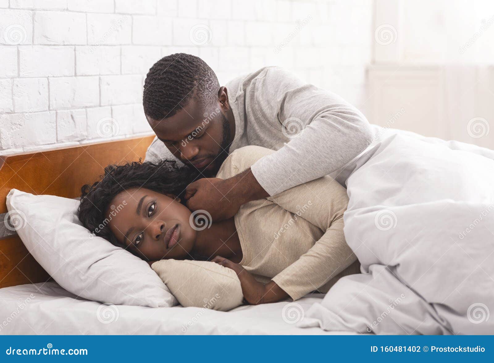 Black woman ignoring husband in bed, refusing to make love. Frigidity concept. Young african american wife refusing to make love with her husband, ignoring him in bed.