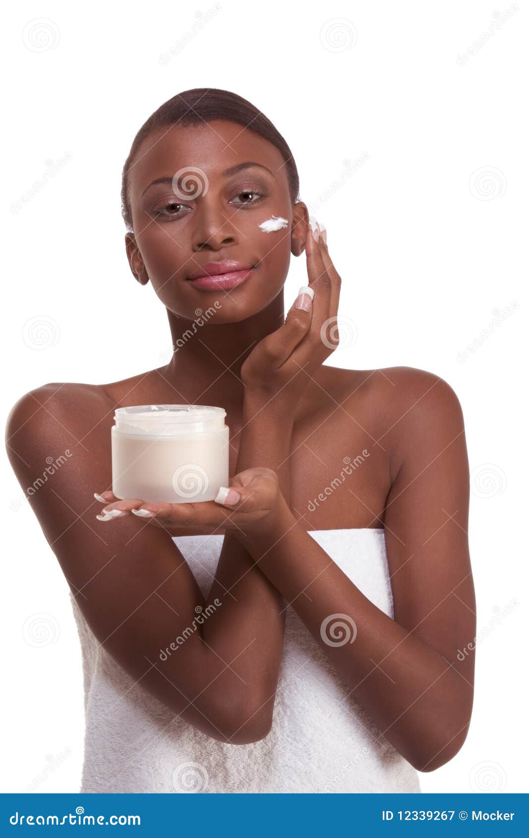 black woman wrapped in towel moisturizing face