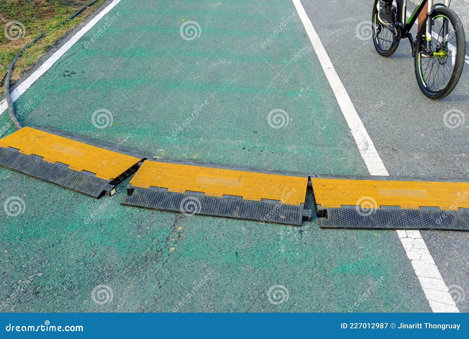 black and yellow heavy plastic covers for people and vehicle to cross over cables laid on road. pavement pads to protect